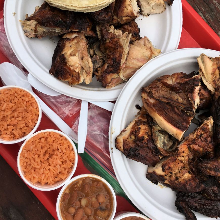 Two plates with pieces of grilled chicken with cups of rice and beans on the side, El Pollo Rey, Kansas City, Kansas