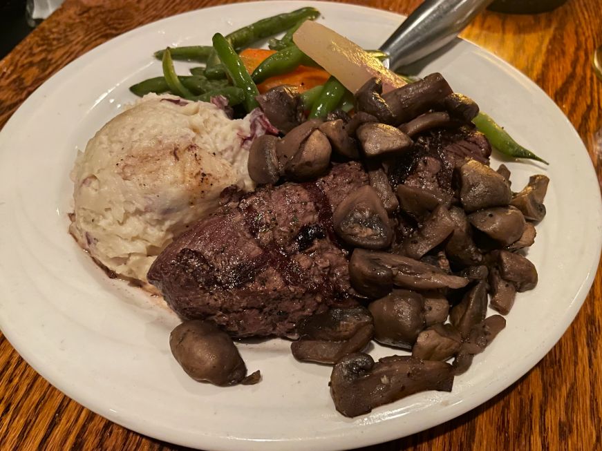 Grilled top sirloin, Chanhassen Dinner Theatres White plate with steak, mushrooms, mashed potatoes, and a side of carrots and green beans