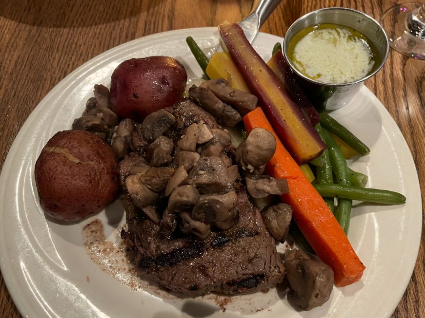 Grilled Top Sirloin at Chanhassen Dinner Theatres Steak with roasted potatoes and carrots, sauteed mushrooms, and a cup of gorgonzola sauce