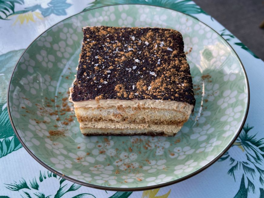 Piece of tiramisu on a blue plate