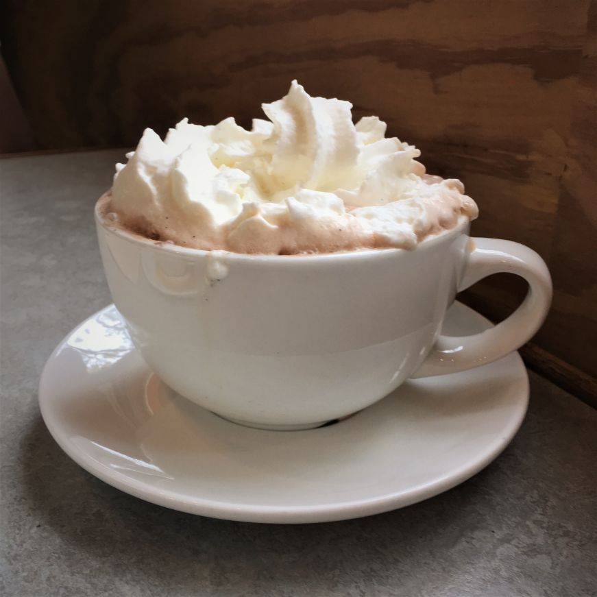 Mug of hot chocolate topped with a large mound of whipped cream, Peace Coffee, Minneapolis Mug of hot chocolate topped with a large mound of whipped cream, Peace Coffee, Minneapolis