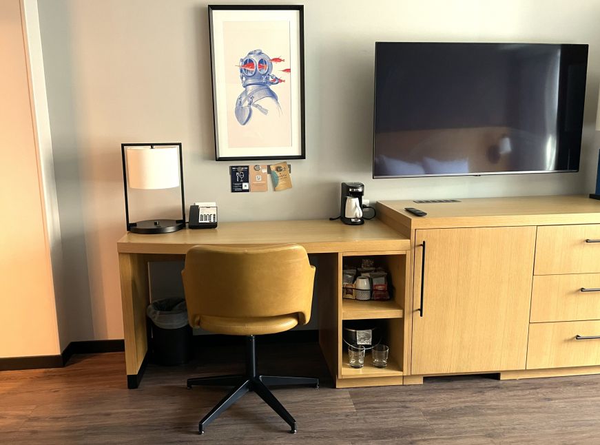Work station in room Hyatt Place Boston Seaport District Light colored wooden desk with a chair