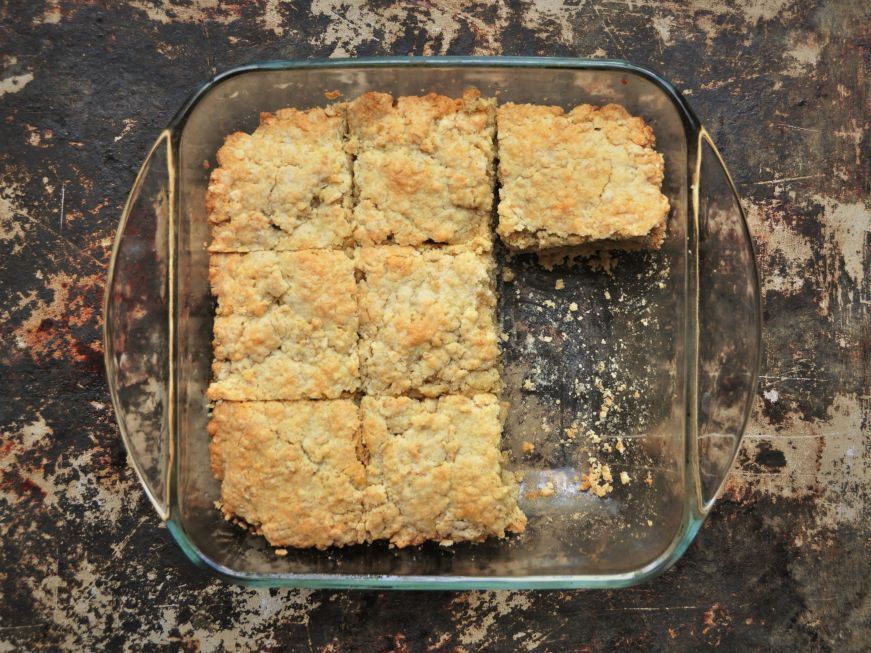 Top down view of a cake in square glass baking dish with two pieces removed