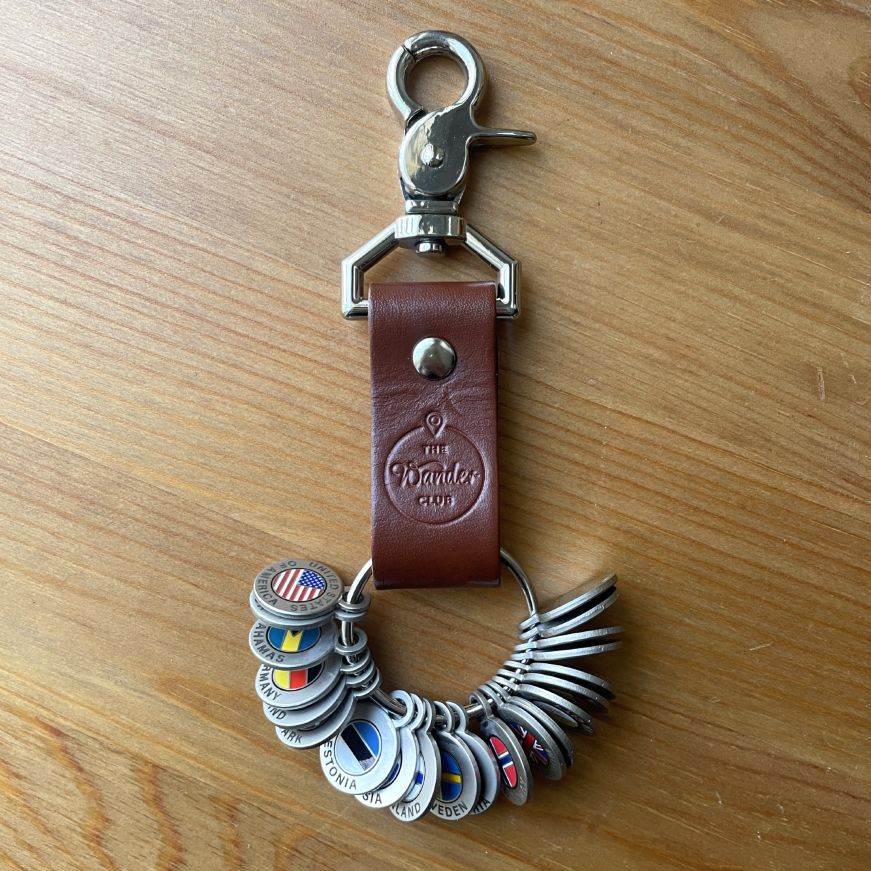 Brown leather keychain with circular tokens depicting country flags