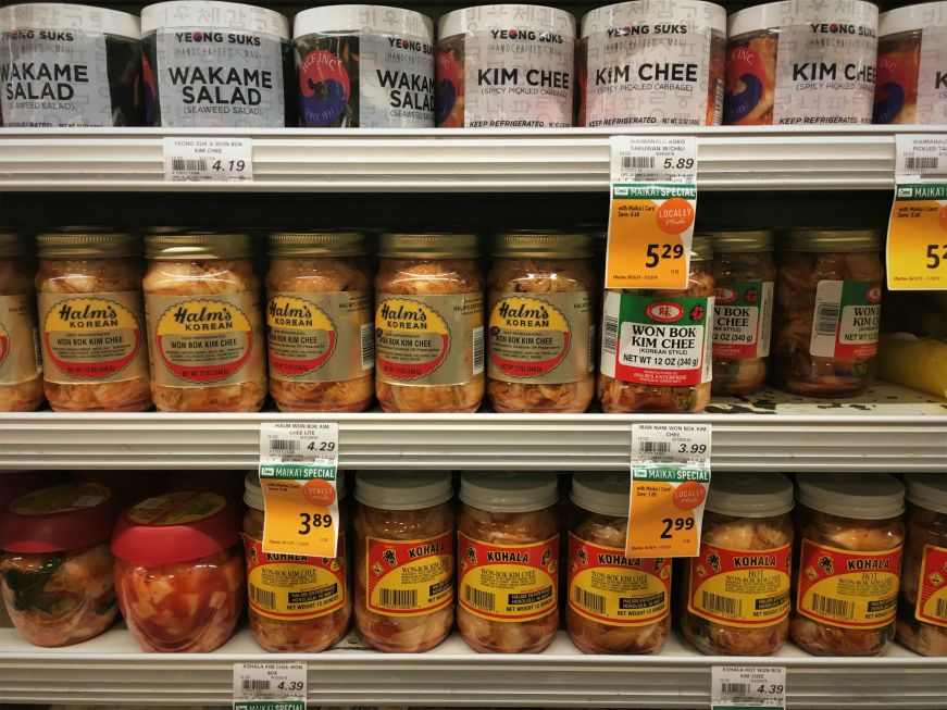 Jars of kimchi on shelves in the produce section of a grocery store, Hawaii