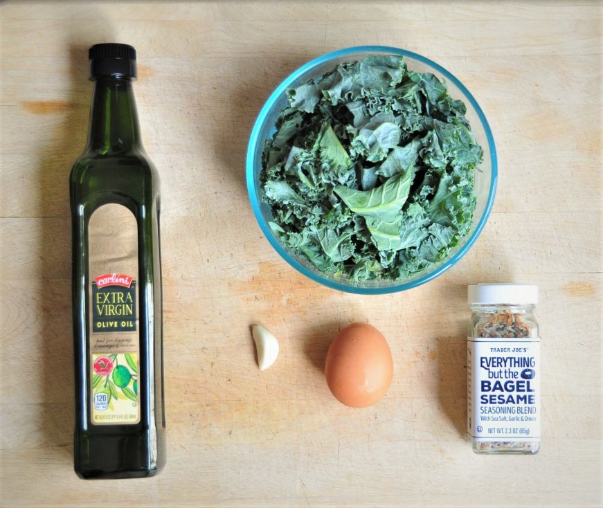 Kale breakfast bowl ingredients arranged on a wooden cutting board