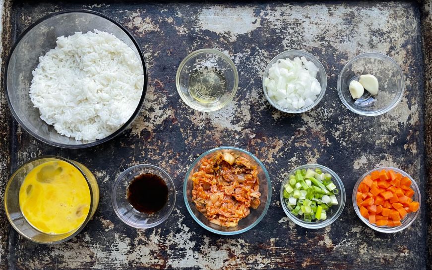 Top down view of baking sheet with ingredients for kimchi fried rice