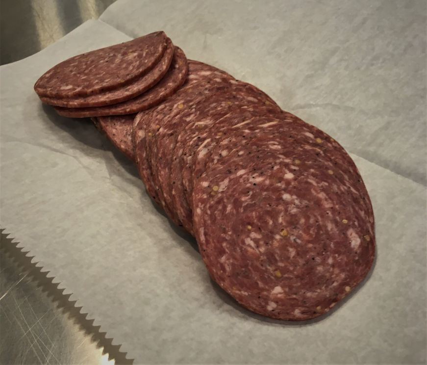 Slices of summer sausage on wax paper on counter at Krizman's Sausage, Kansas City, Kansas