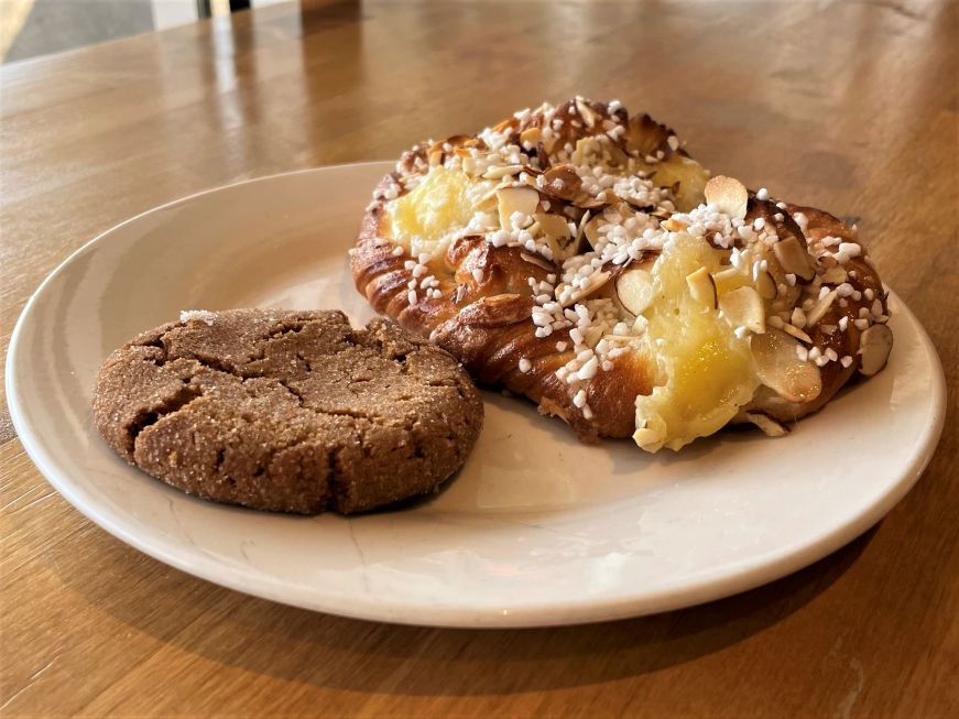 Krown Bakery & Eatery Plate with a cookie and a twisted pastry filled with custard and topped with pearl sugar