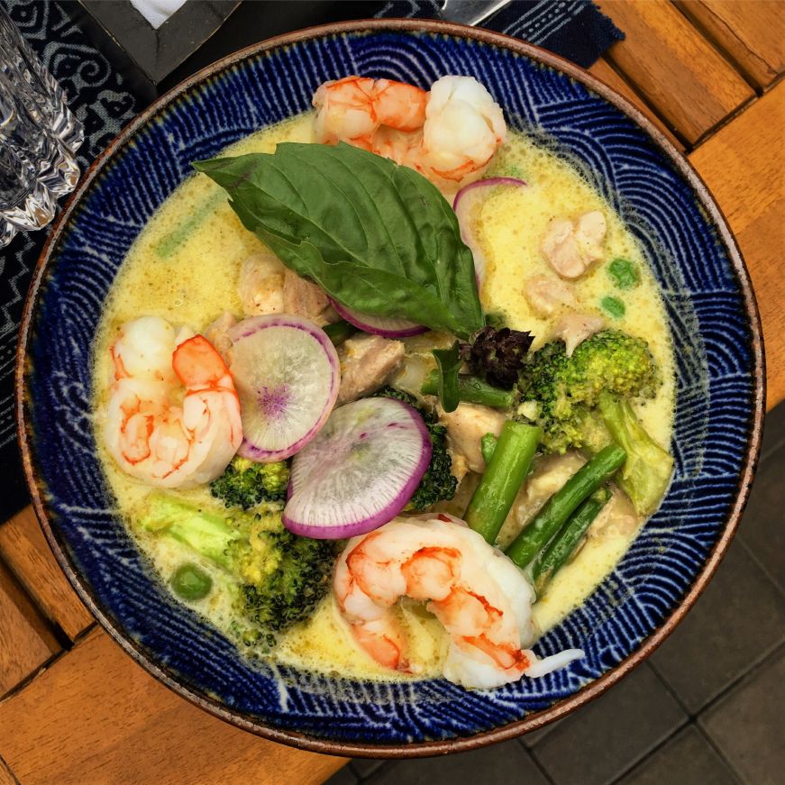 Lat14 Asian Eatery Yellow soup with vegetables, shrimp, and fresh herbs