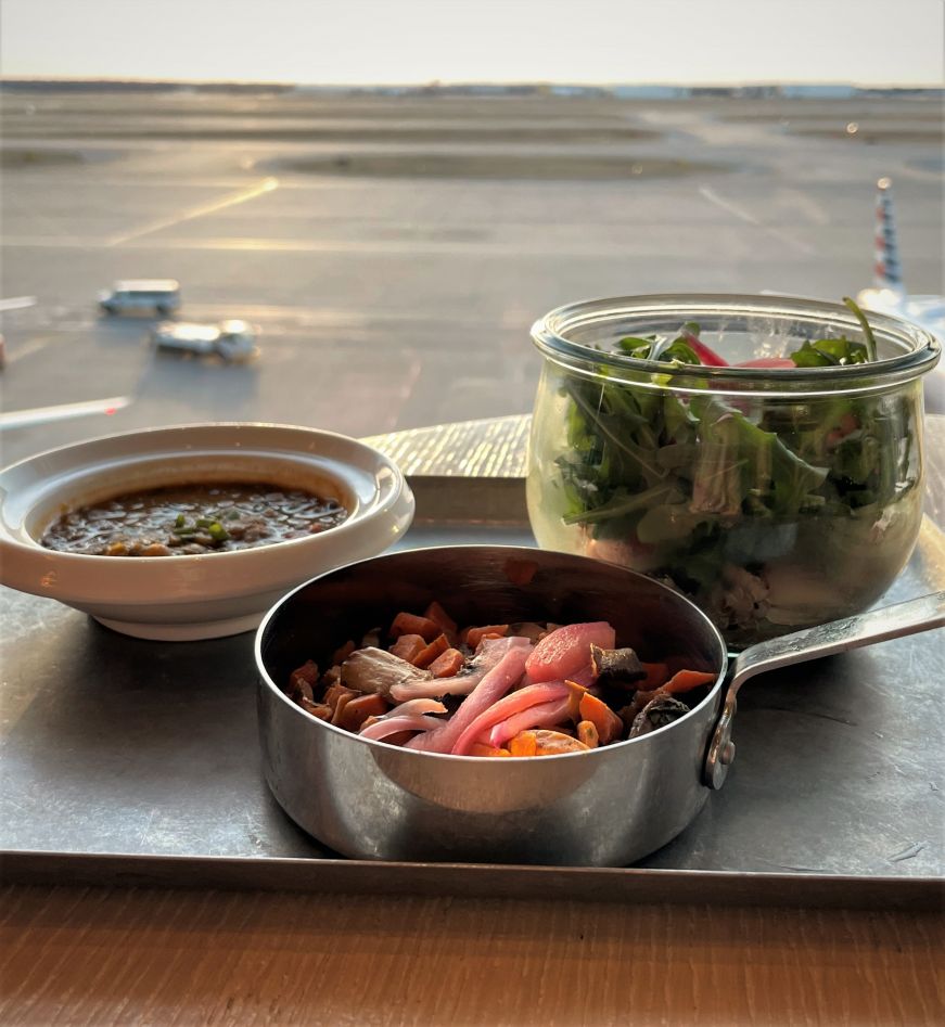 Small dishes of lentils, roasted vegetables, and salad on a metal tray