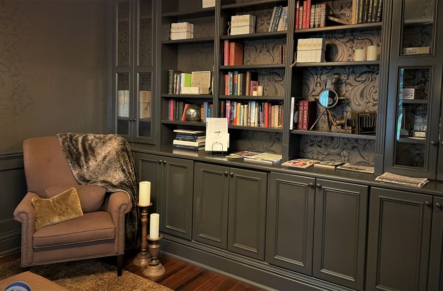 Library with dark gray shelves and armchair