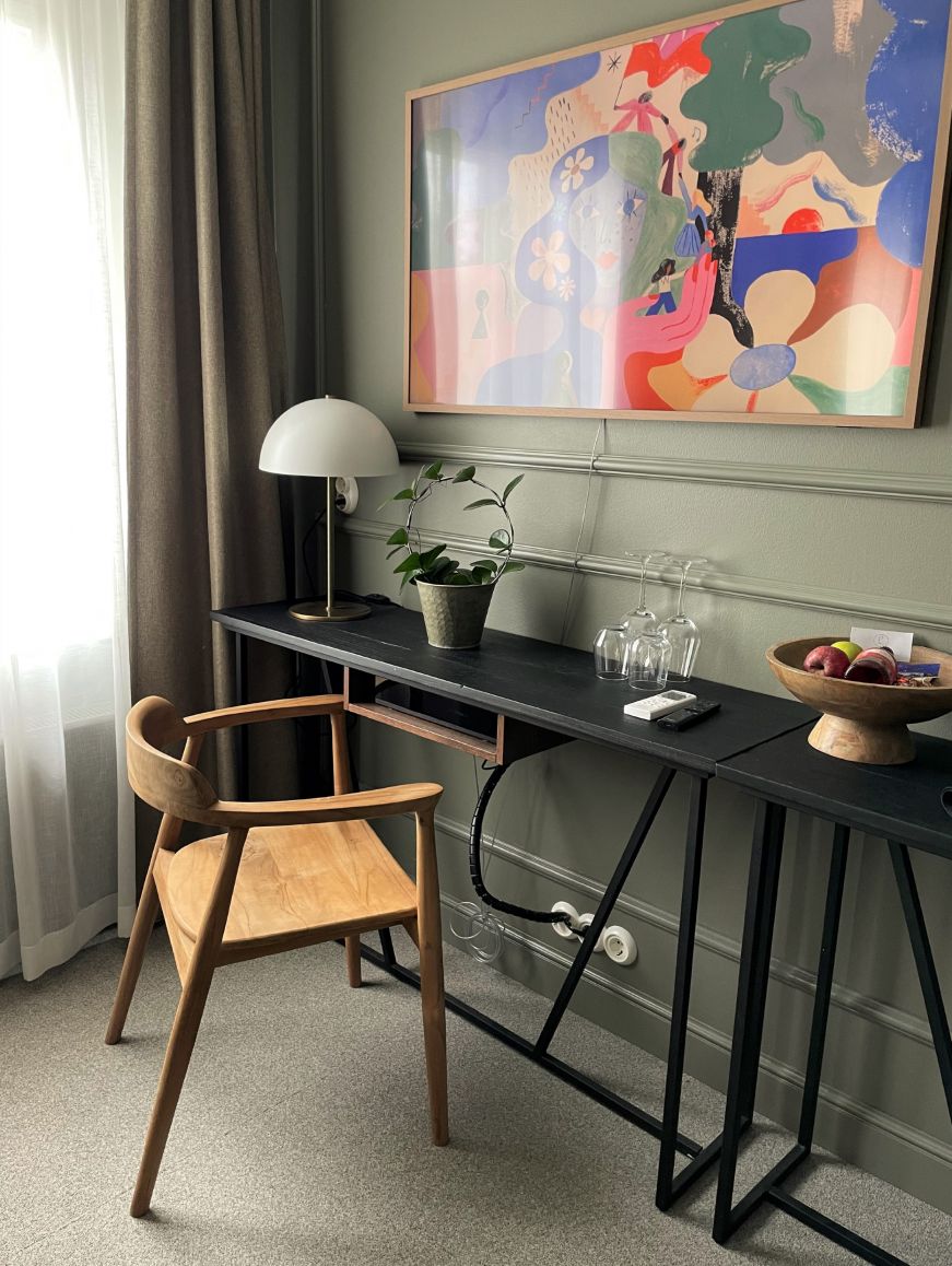 Deluxe double room, Lillan Hotel Desk and wooden chair in the corner of a hotel room