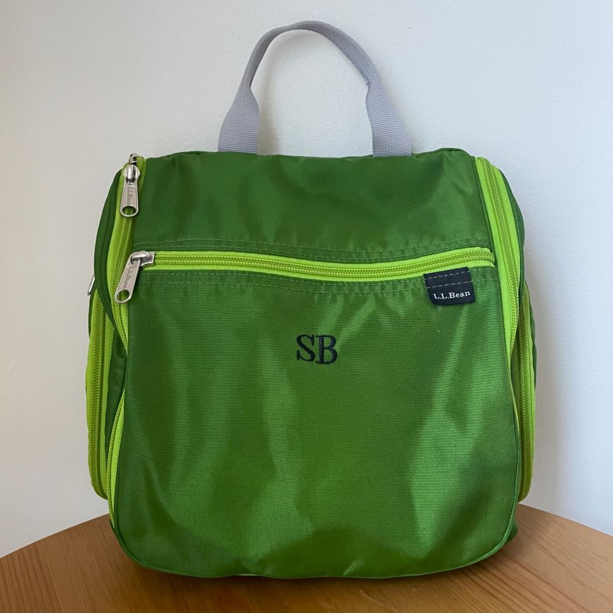 Green nylon toiletry bag monogrammed with "SB"