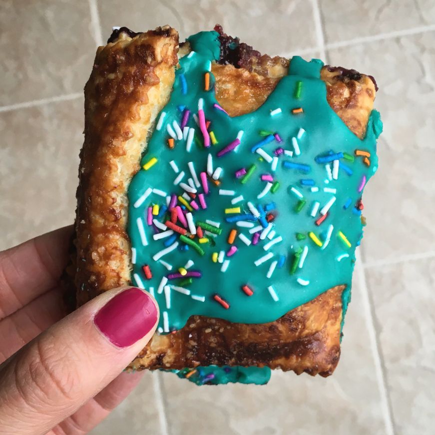 Homemade pop tart with bright blue icing and rainbow sprinkles