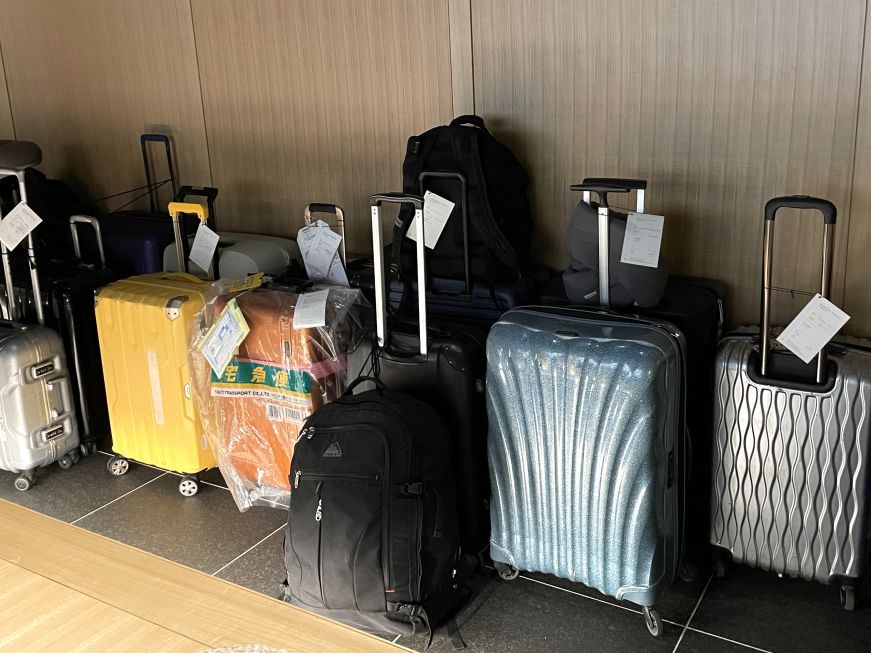 Luggage waiting to be shipped in the lobby of our Tokyo hotel Assortment of suitcases in a hotel lobby, each with a luggage shipping tag