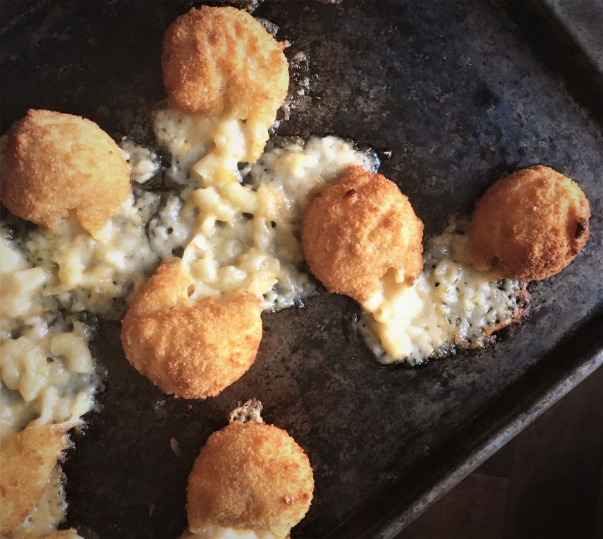 Oozing mac and cheese bites on a baking sheet
