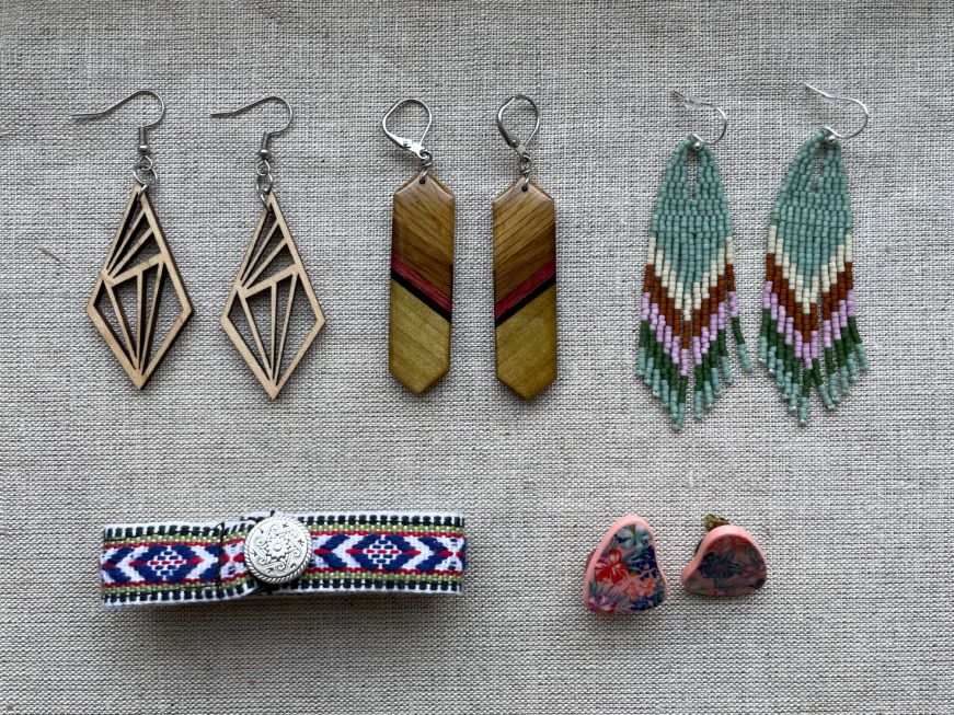 Top down view of several pairs of earrings and a bracelet