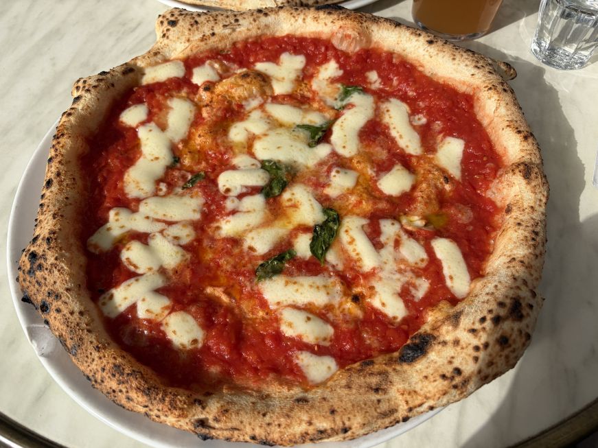 Pizza with tomato sauce, gobs of mozzarella cheese, and fresh basil