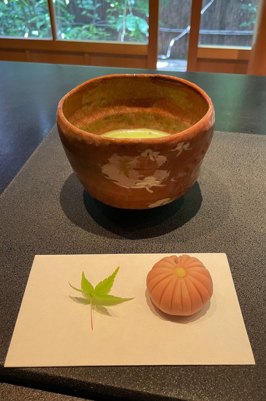 Cup of matcha and pumpkin-shaped sweet