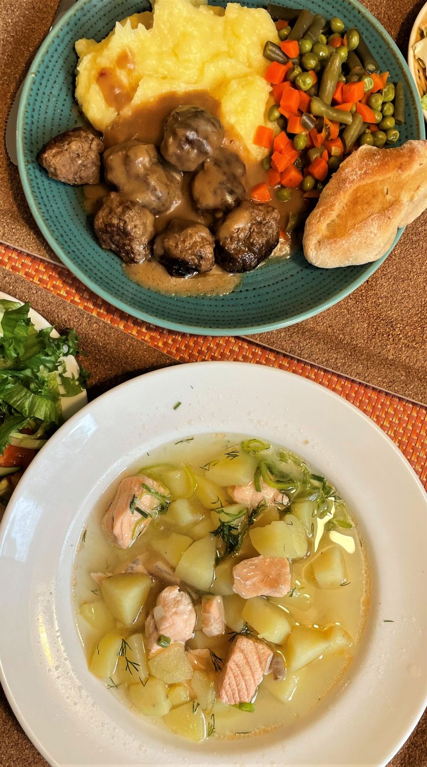 Plate of meatballs, mashed potatoes, and vegetables and bowl of salmon soup