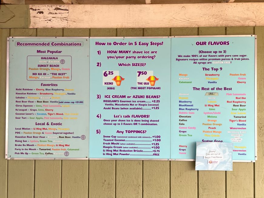 Large menu board listing shave ice flavors and topping options