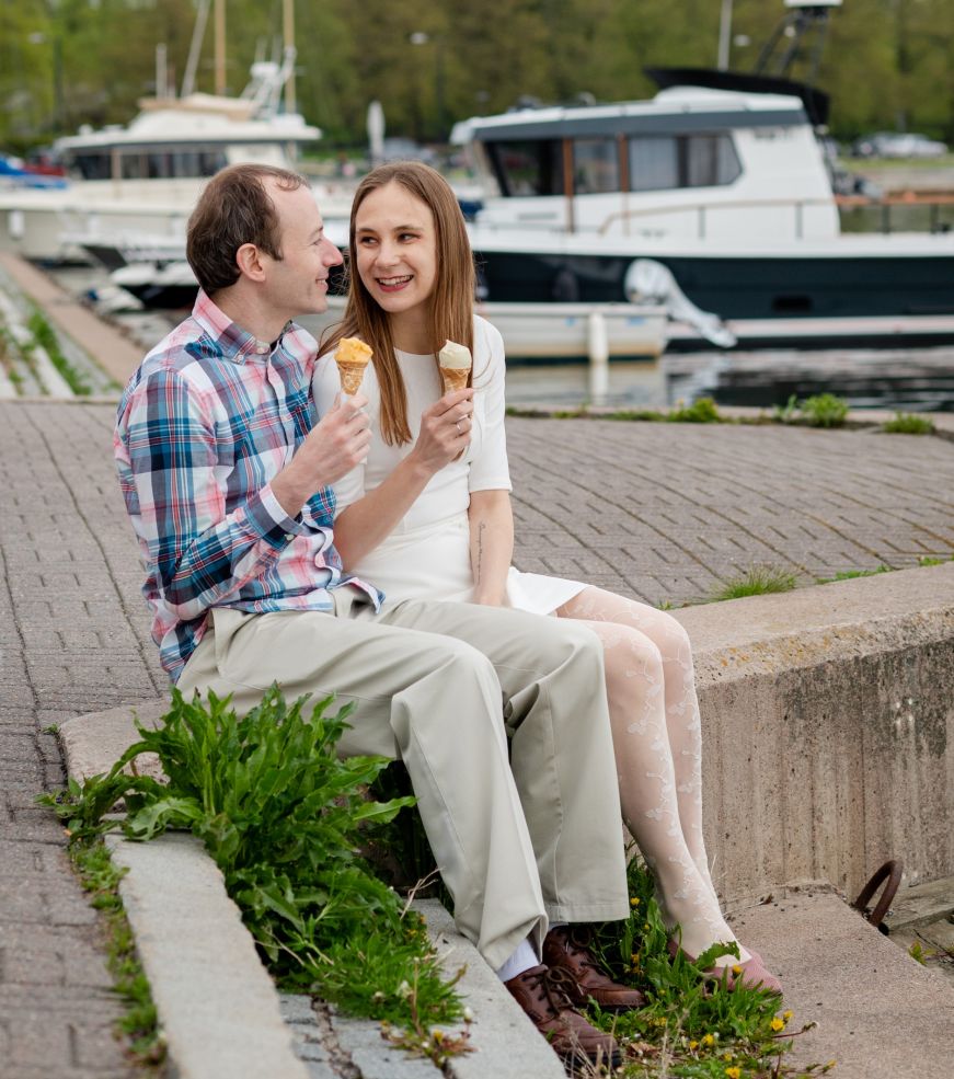 Mike and Stacy eating gelato cones at the edge of a harbor