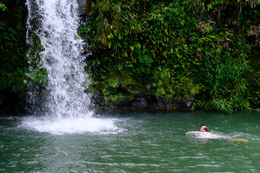 Man swimming in a waterfall-fed pool