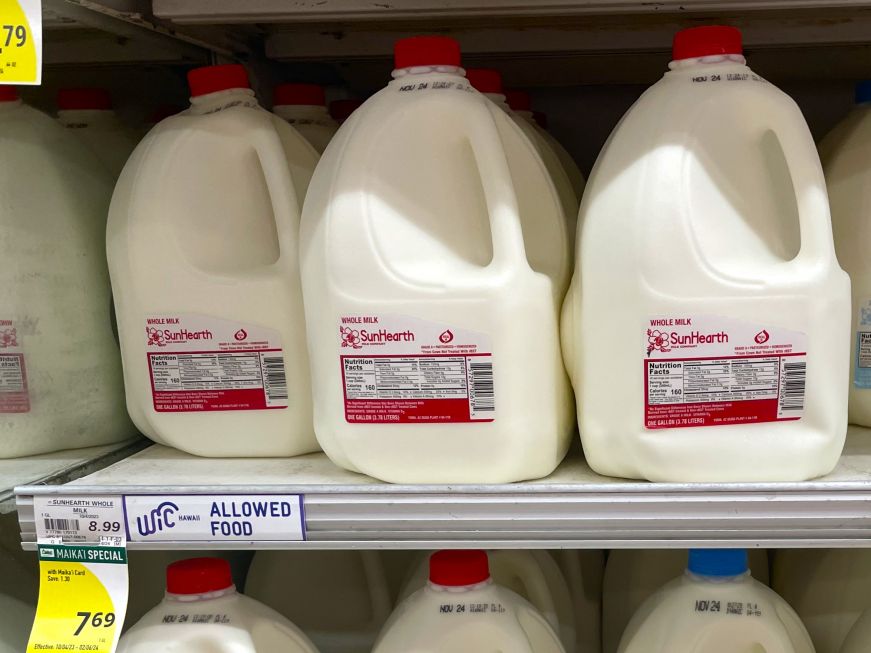 Shelf of milk with price tags