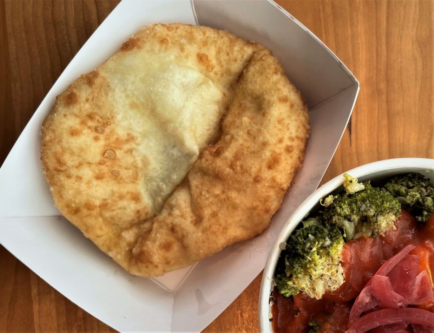 Piece of fry bread in a cardboard dish