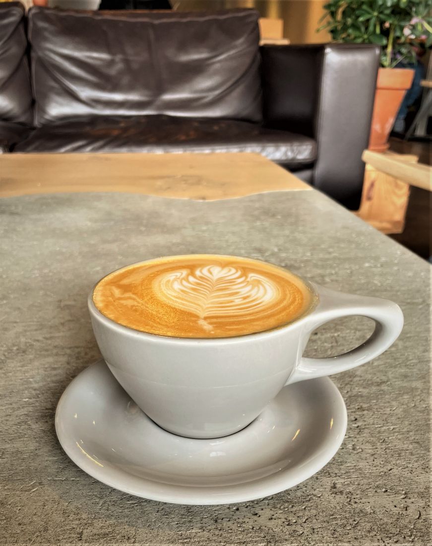 Latte with latte art with leather sofa in the background