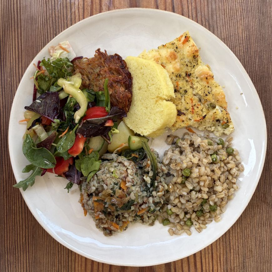 Plate with servings of whole grains with vegetables, salad, potato pancake, and cheese casserole