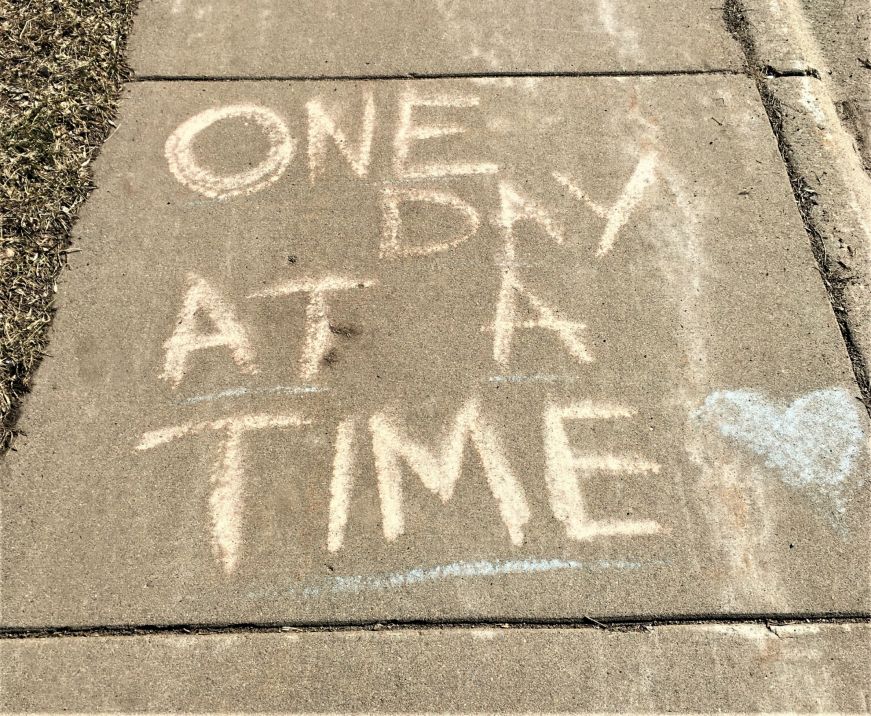 Sidewalk with "One day at a time" written in chalk