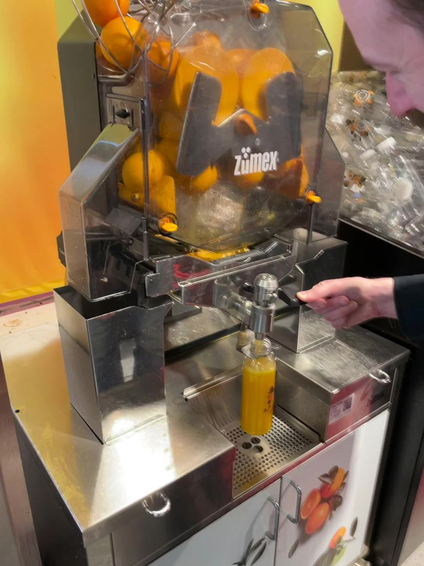 Mike using a fresh squeezed orange juice dispenser