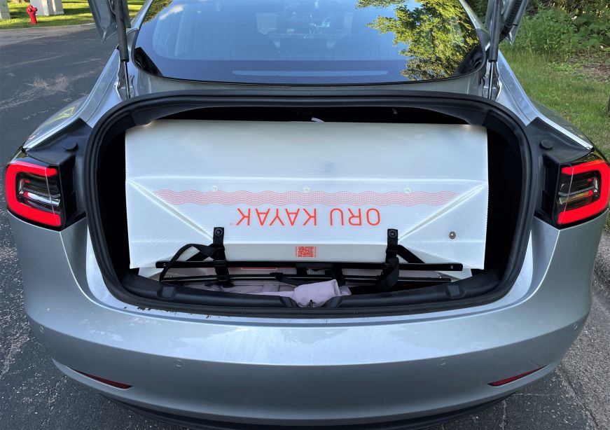 Folded up kayak in the trunk of a gray sedan