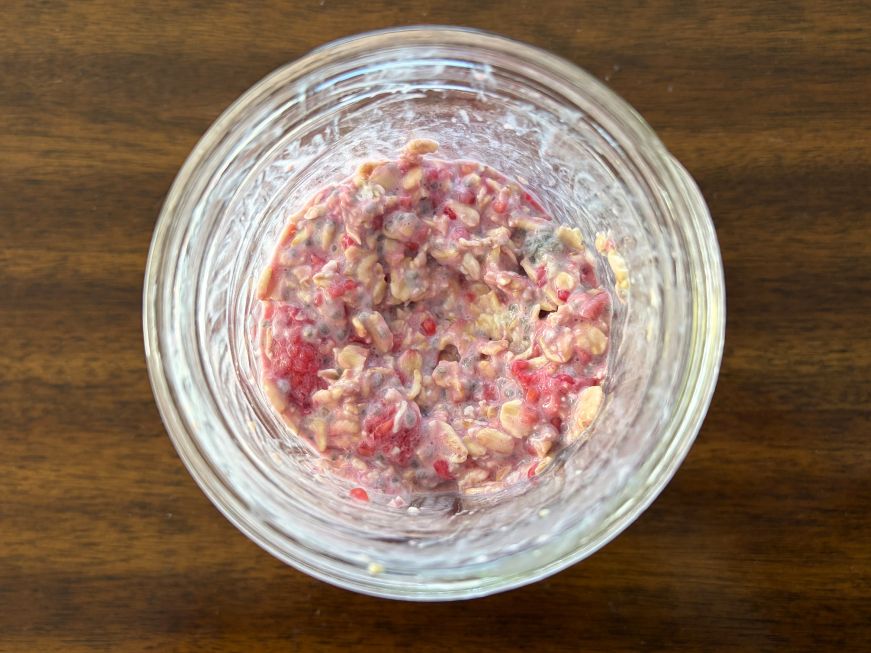 Top down view of a Mason jar of overnight oats made with raspberries and chia seeds