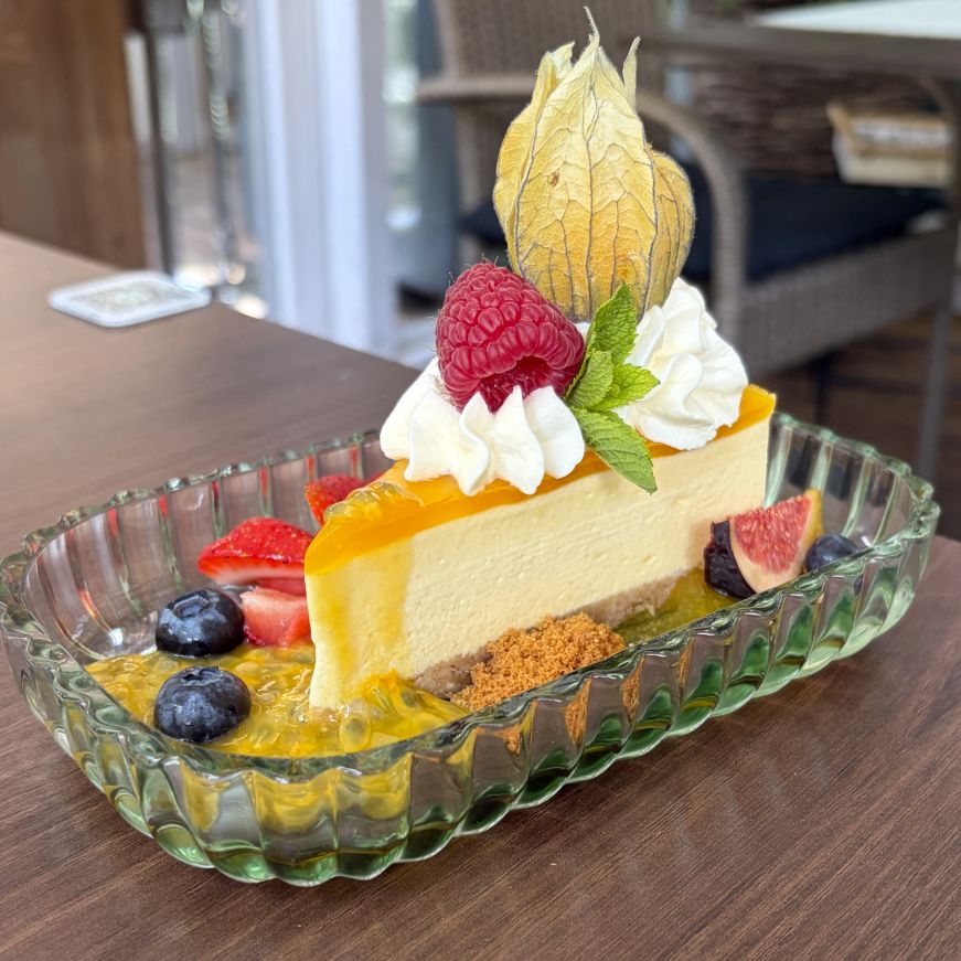 Piece of cheesecake on a plate beautifully garnished with fruit