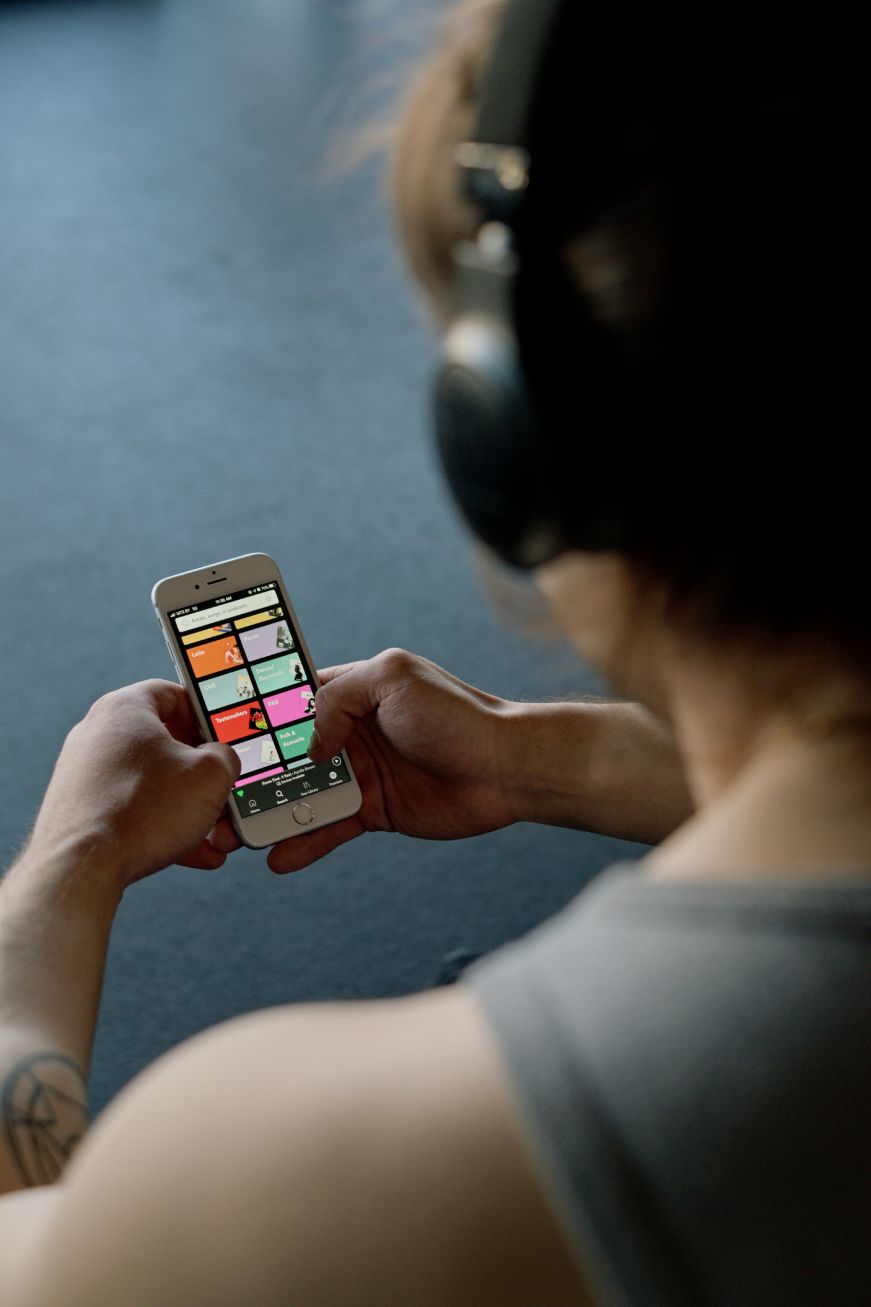 Man wearing headphones and looking at his phone