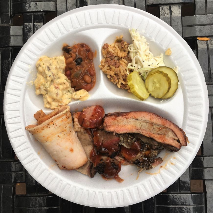 Plastic plate with a dozen small portions of various barbecue meats and sides, Kansas City, Kansas
