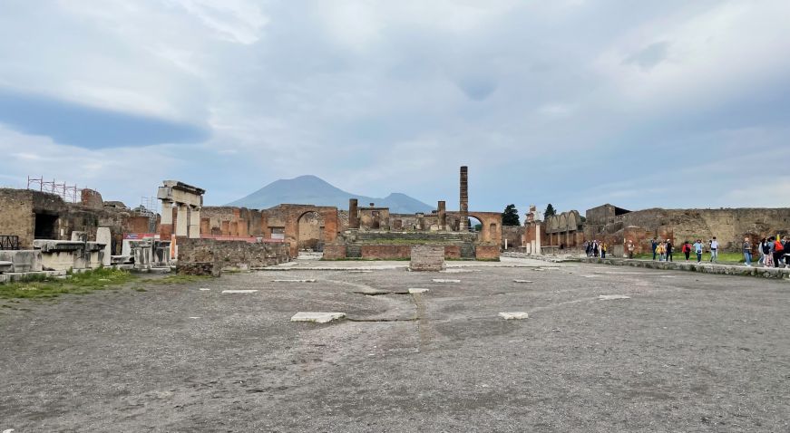 Open space surrounded by ruins with a mountain in the background
