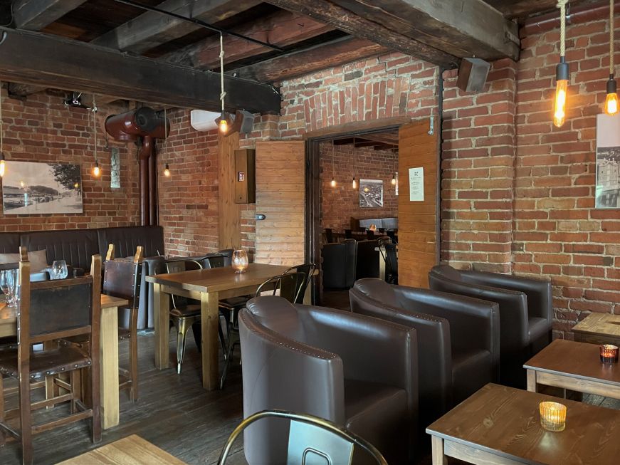 Interior of restaurant with exposed brick walls and wood roof beams