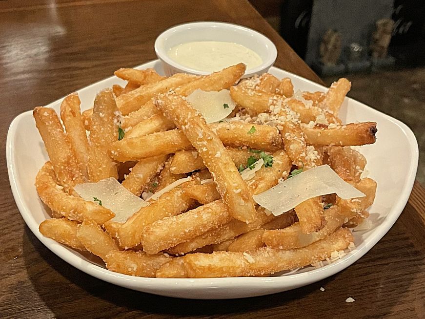 Parmesan truffle fries, Pour Wine Bar & Bistro, Champlin Plate of fries topped with shaved and grated Parmesan cheese
