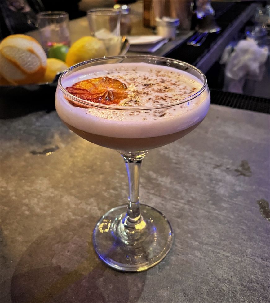 Proud to Partake of Your Pecan Pie, Copperwing Distillery, St. Louis Park Cocktail in a coupe glass sitting on a bar