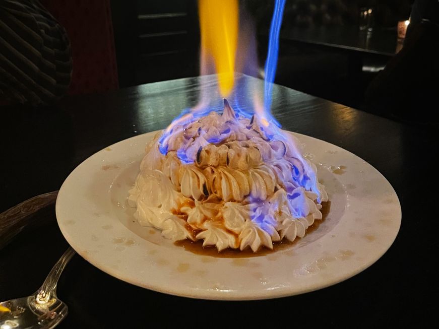 Baked Alaska with a blue flame toasting the meringue