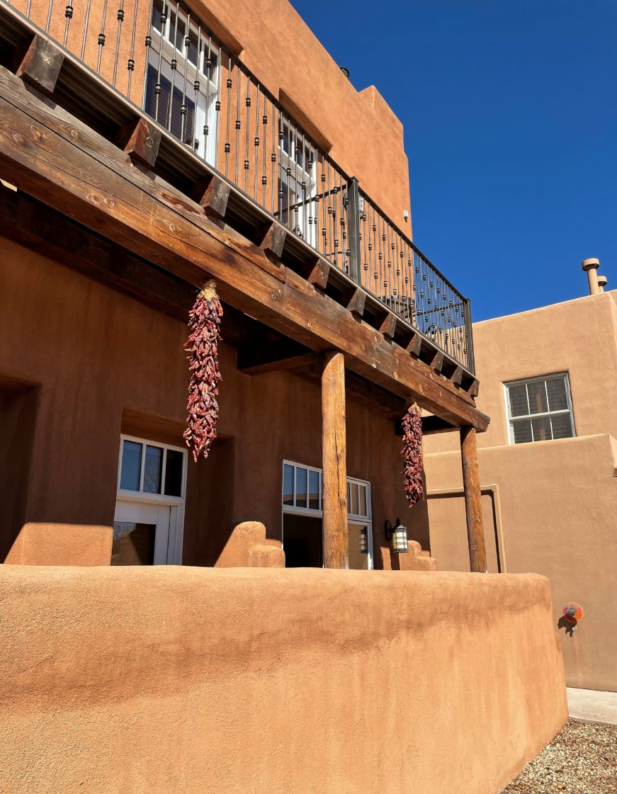 Pueblo Revival house with dried chiles hanging from porch