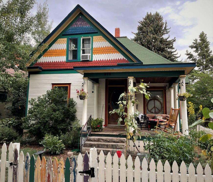 White cottage with a front porch and brightly colored accents