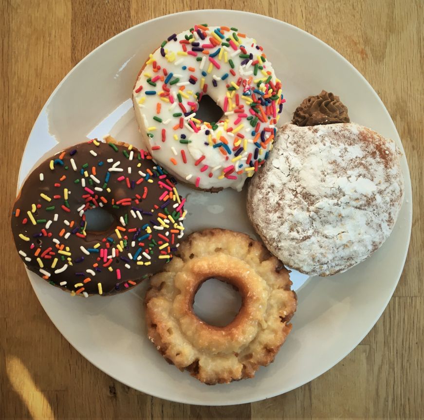 Raised donuts with sprinkles, glazed old fashioned, and puffy cream bismark, Puffy Cream Donuts Plus Top down view of a plate with four donuts