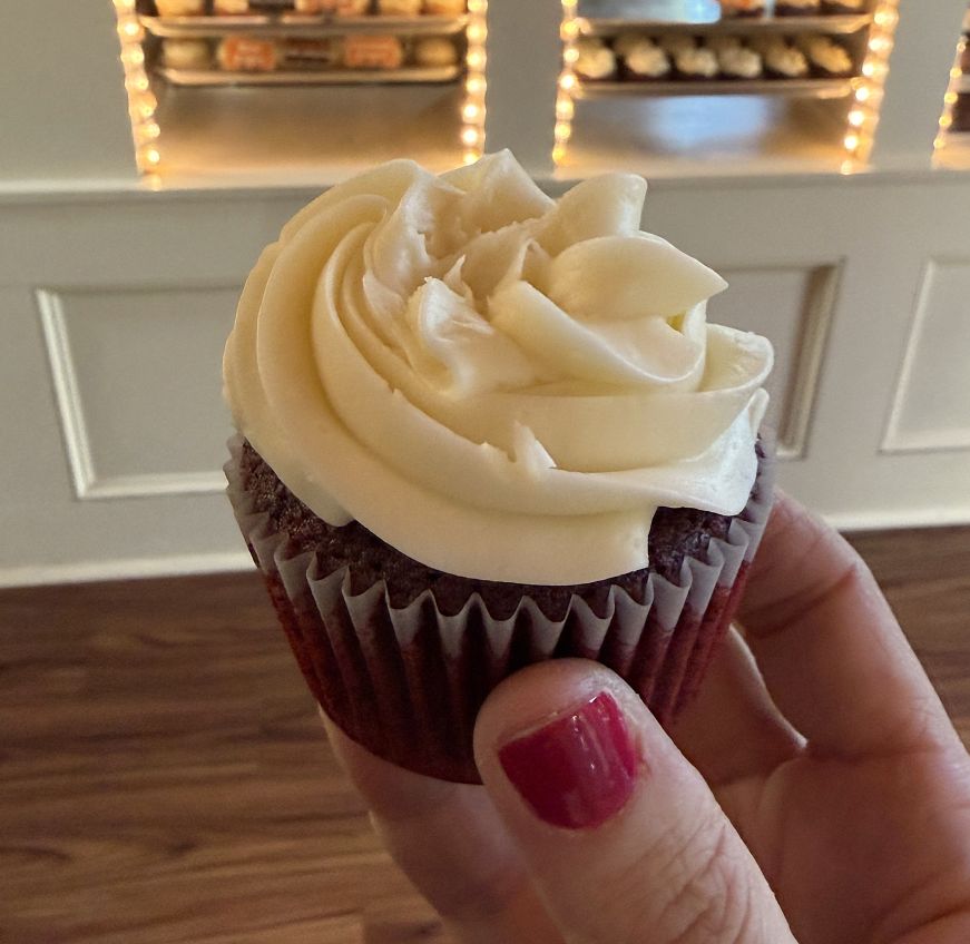 Hand holding a red velvet cupcake