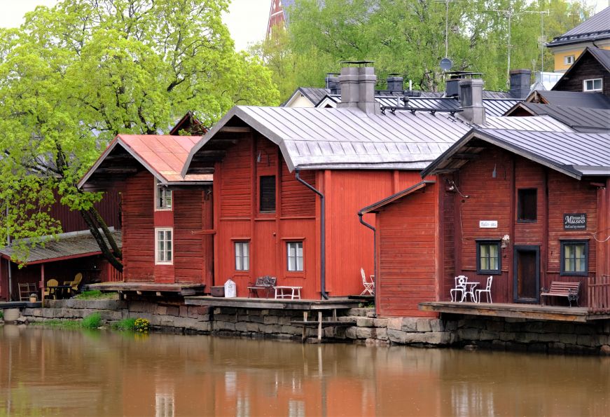Row of red wooden buildings along a river