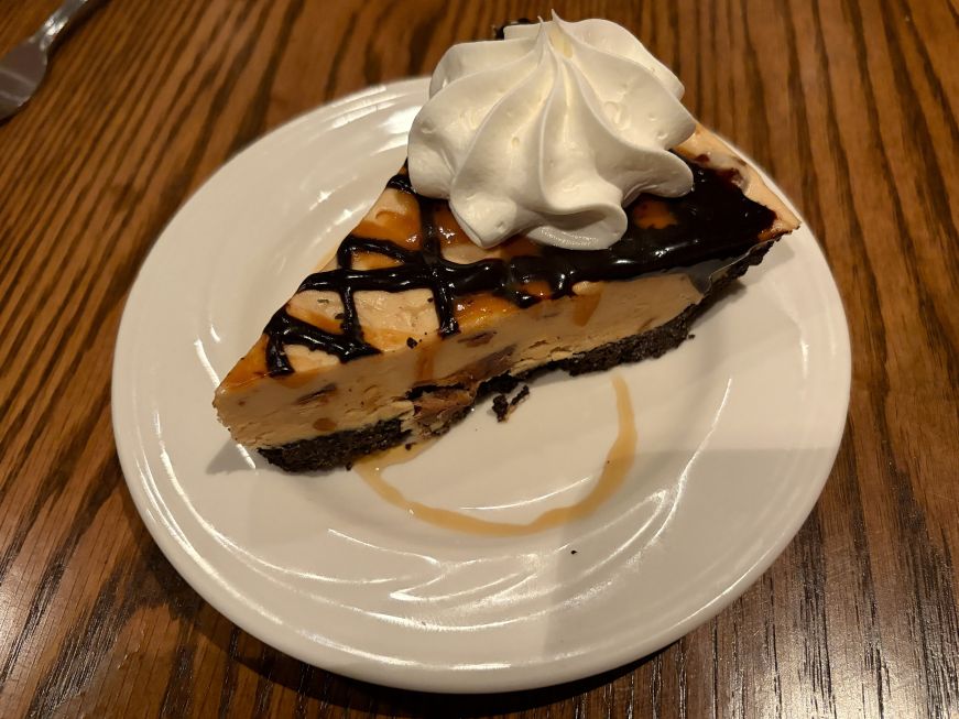 Peanut butter mousse pie drizzled with chocolate and garnished with whipped cream